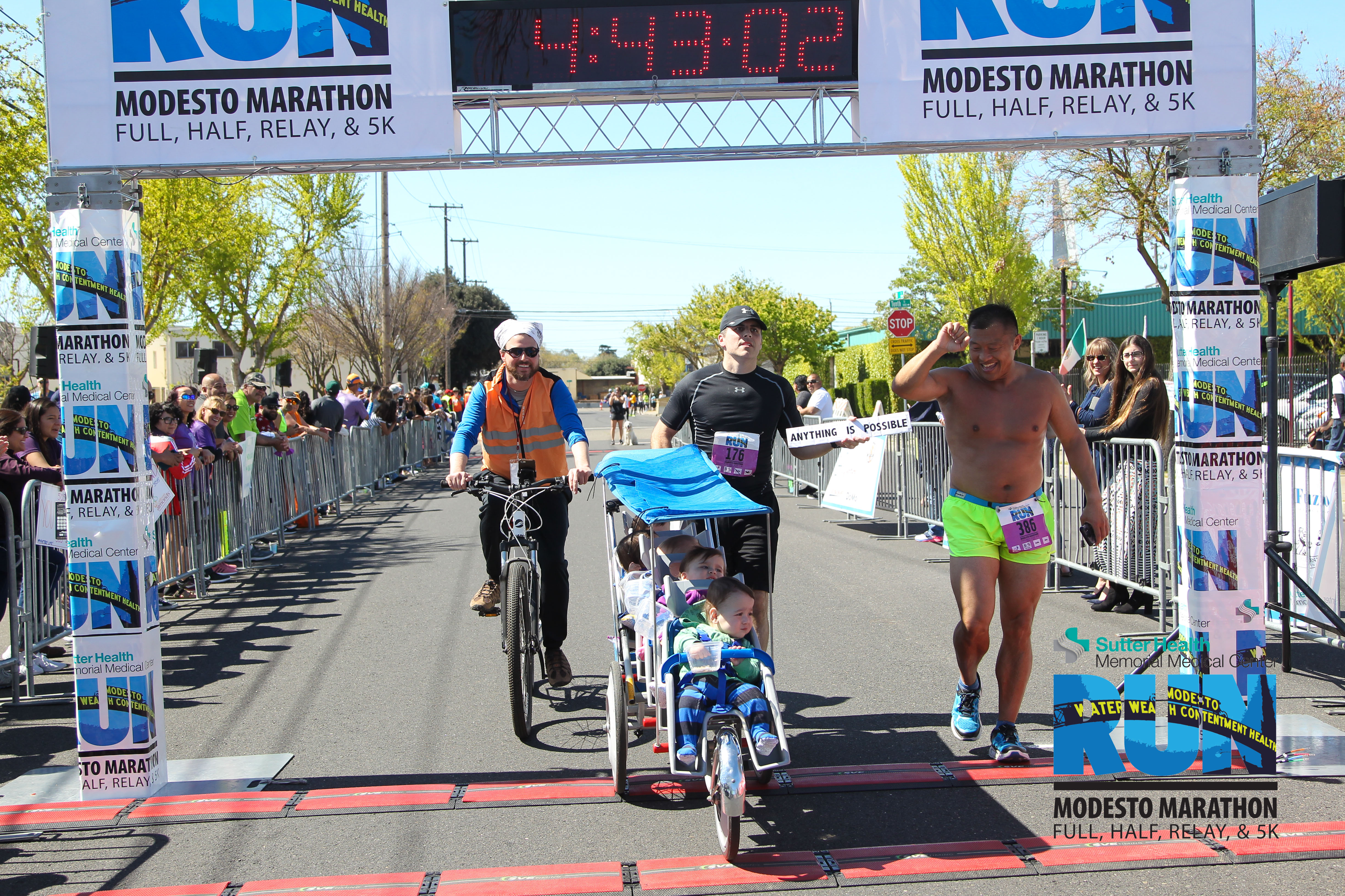 Chad Kempel crossing the finish line at the Modesto Marathon with quintuplets in a stroller — Guinness World Records title 4:42:49