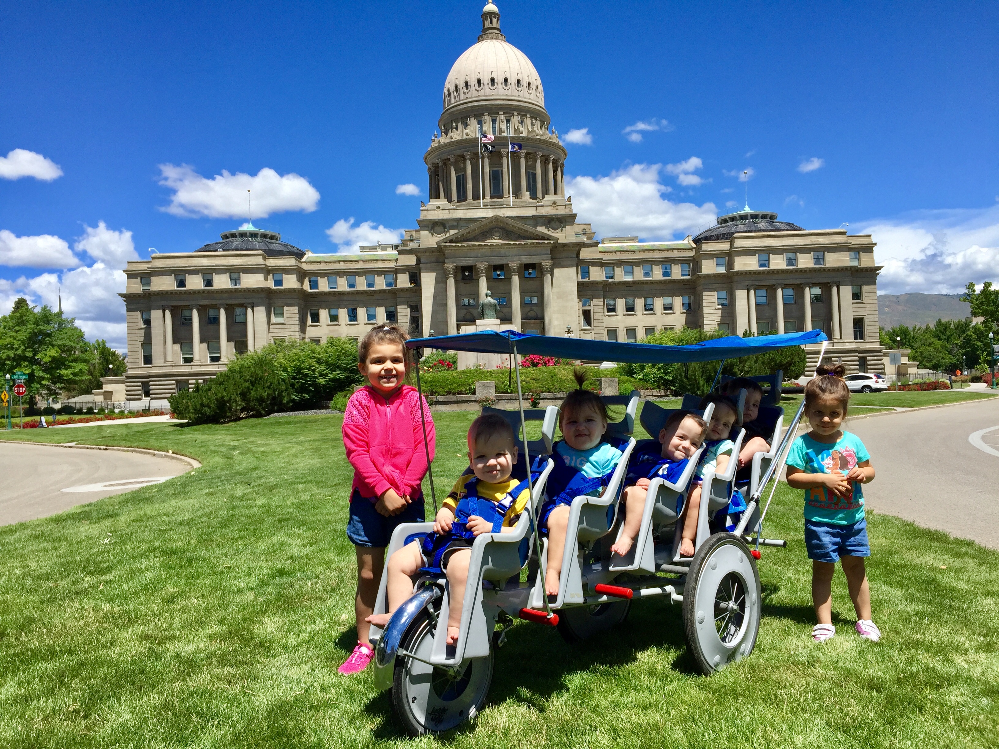 Kempel quintuplets and older sisters with the Guinness World Record stroller in front of the Idaho State Capitol building in Boise